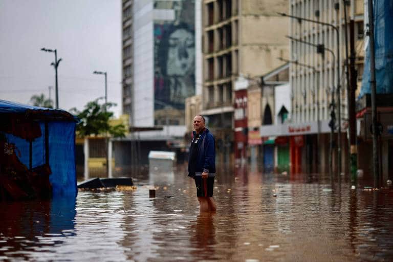 Um homem em uma rua alagada no Centro Histórico de Porto Alegre, Rio da Grande Sul. AFP/Anselmo Cunha